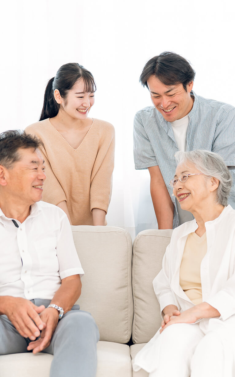 談笑する若い夫婦とシニア夫婦の家族の写真